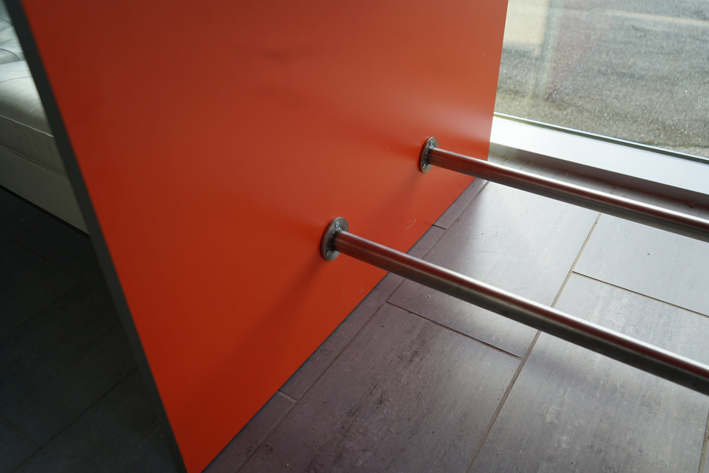 Orange sidepanel og stålstøtter på Fumac højbord – moderne kontrastdesign.