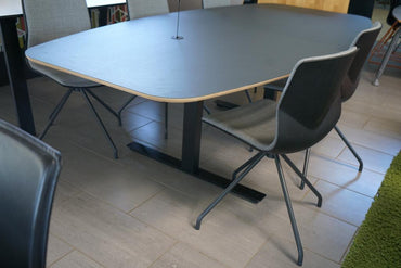 Fuld visning på afstand af Fumac konferencebord – sort linoleumsplade, birkefiner kant og stilrene sorte ben.