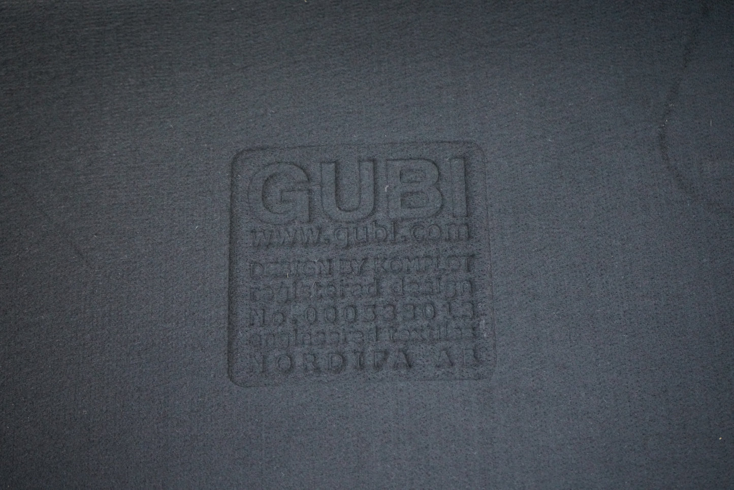 GUBI logo på loungestol i antracit filt