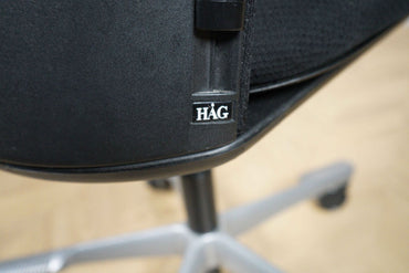 Nærbillede af Håg Futu kontorstolens grå stel og sorte sæde, der viser materialekvalitet og finish.