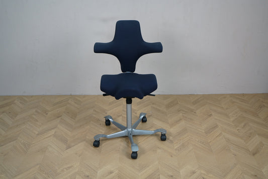 HÅG Capisco 8106 kontorstol i mørkeblå Fame set forfra med sølv aluminiumsfodkryds.