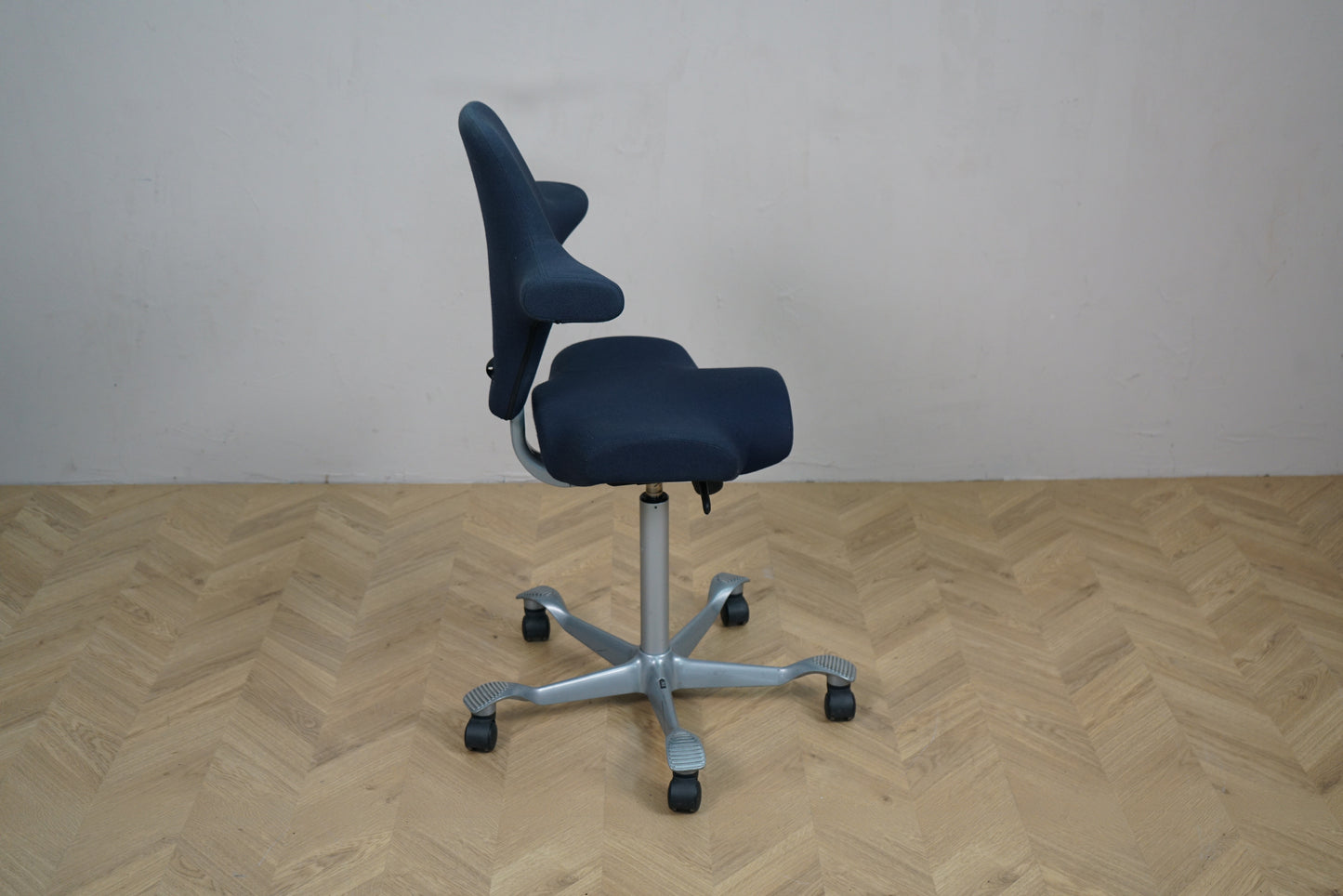 HÅG Capisco 8106 kontorstol i mørkeblå Fame vist fra siden med ergonomisk sadelsæde.