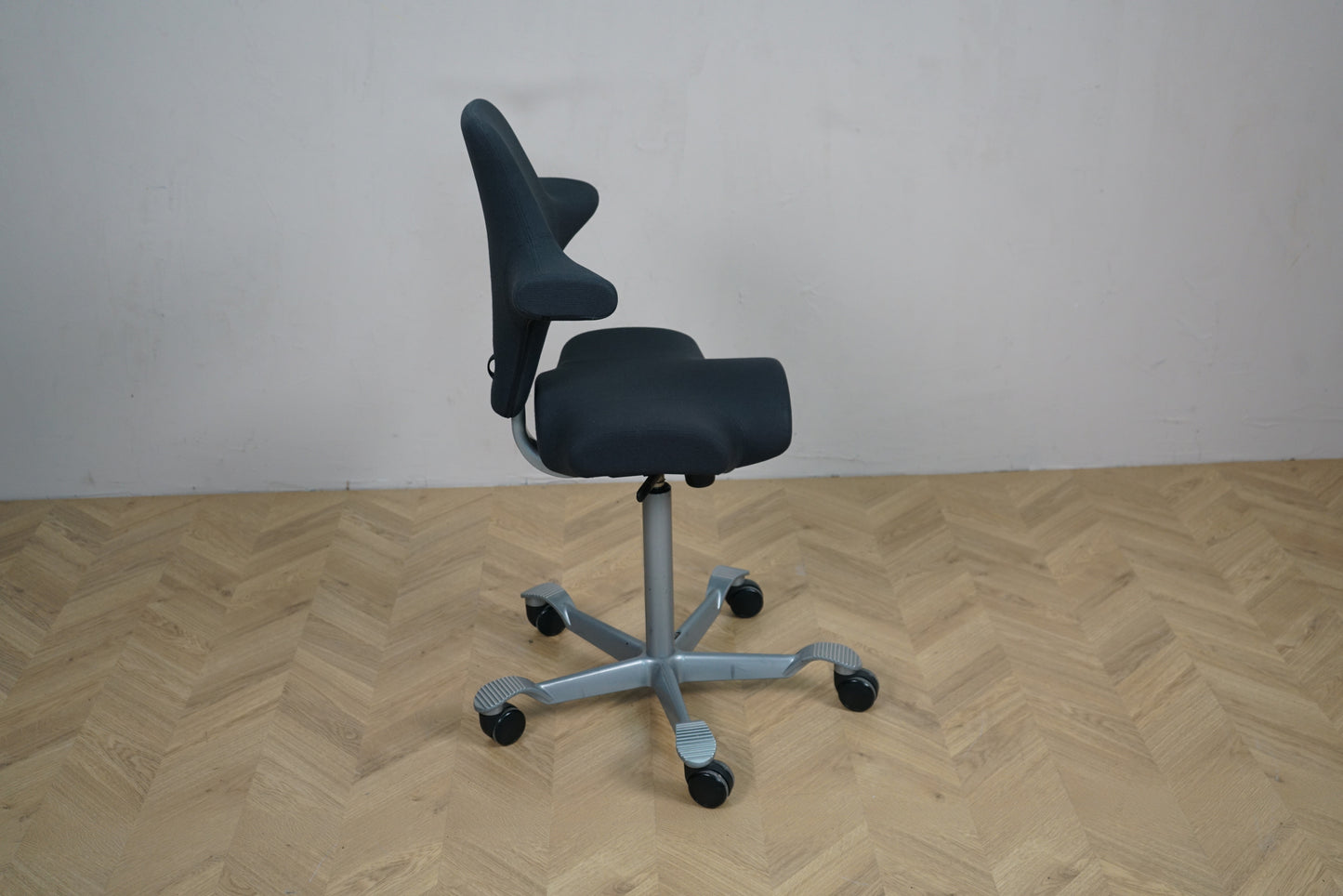 HÅG Capisco 8106 kontorstol i sort Fame vist fra siden med ergonomisk sadelsæde.