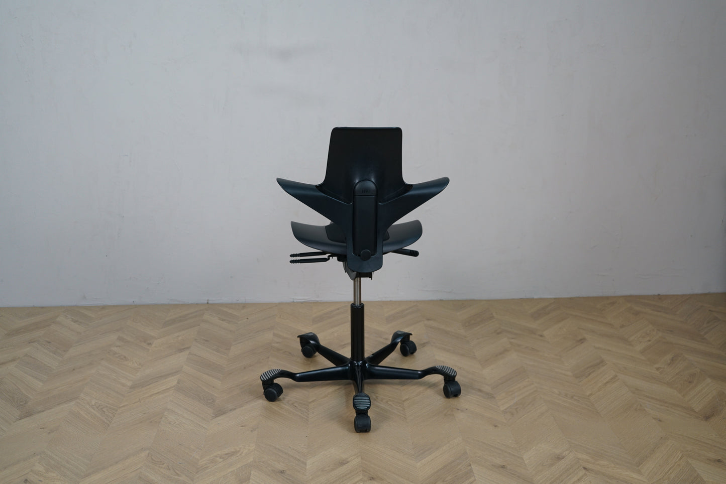 HÅG Capisco Puls 8010 sort ergonomisk kontorstol set bagfra – elegant ryglæn med justeringsgreb.