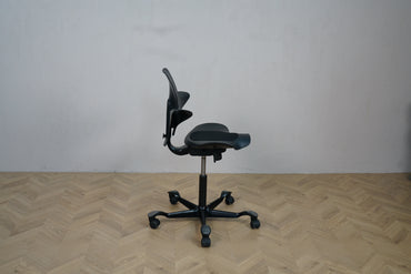 HÅG Capisco Puls 8010 sort kontorstol set fra siden – viser justerbart sæde og ryglæn.