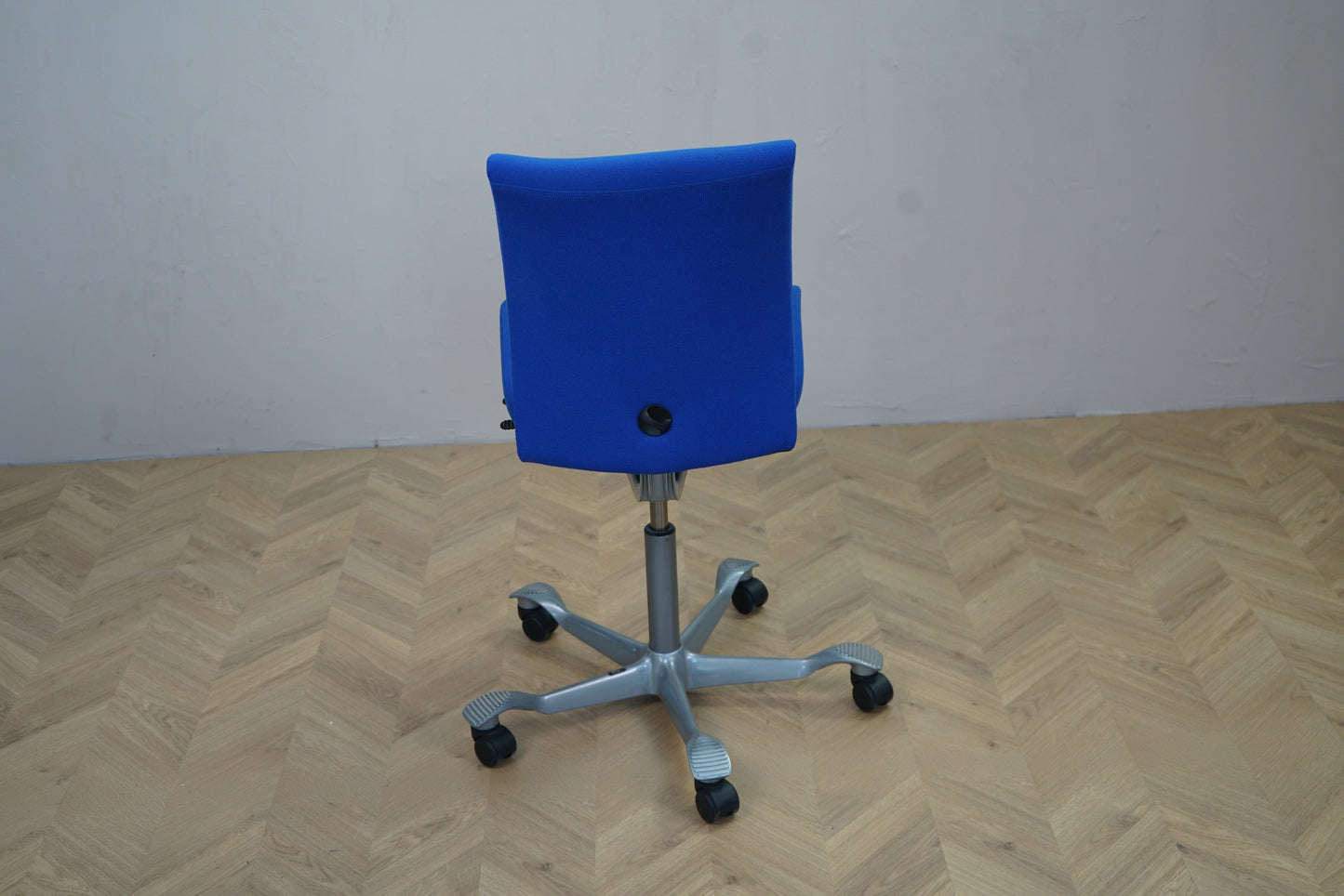 HÅG H04 4400 kontorstol i blå Fame med gråt stel set bagfra. Moderne kontorstol med hjul og ergonomisk design.