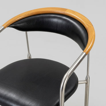 Nærbillede af Henrik Tengler Chairman designerstol med sort læderbetræk, kopstykke i ahorn og detaljer i børstet stål.