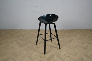 HAY AAS32 sort høj barstol med formstøbt sæde og træben set fra skrå vinkel.