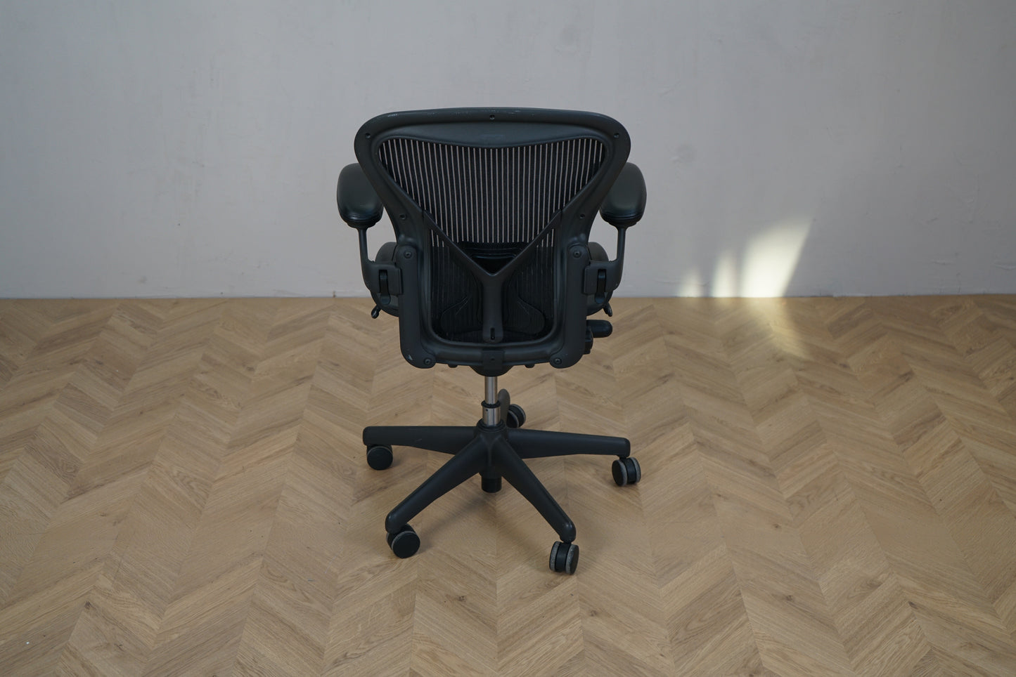 Herman Miller Aeron kontorstol i sort, størrelse A, set bagfra med ventilerende mesh-ryg og ikonisk ergonomisk design