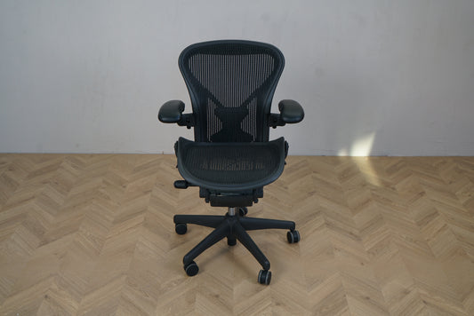 Herman Miller Aeron kontorstol i sort, størrelse A, set forfra med ergonomisk mesh-ryglæn og justerbare armlæn