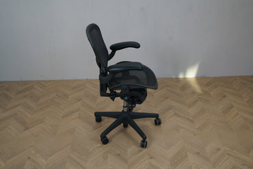 Herman Miller Aeron kontorstol i sort, størrelse A, set fra siden med justerbar sædehøjde og fuldt ergonomisk design