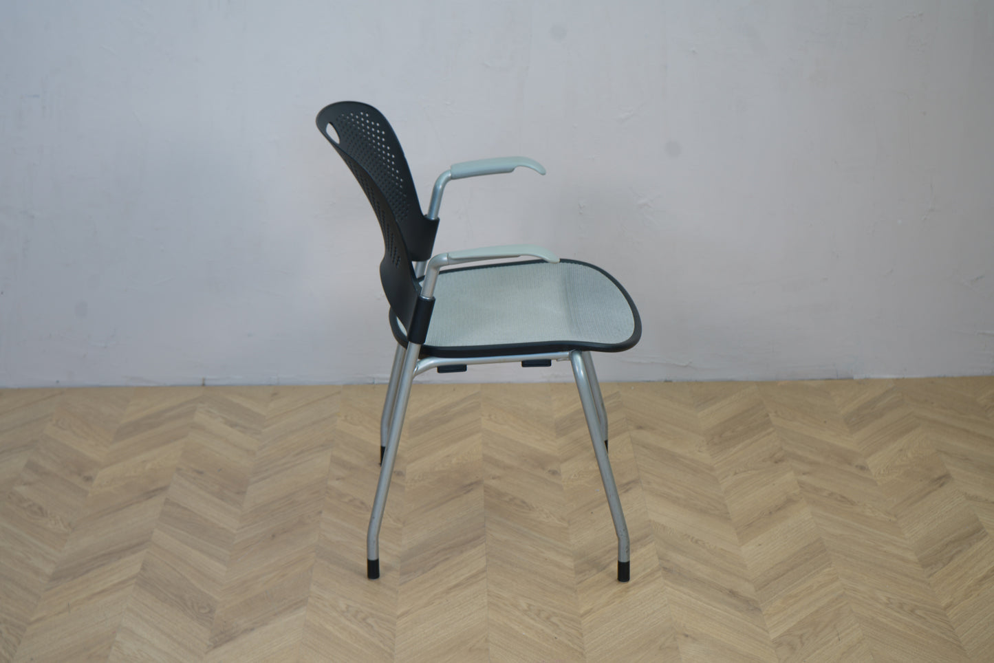 Herman Miller Casper konferencestol set fra siden, viser armlæn og let buet ryglæn i sort plast.