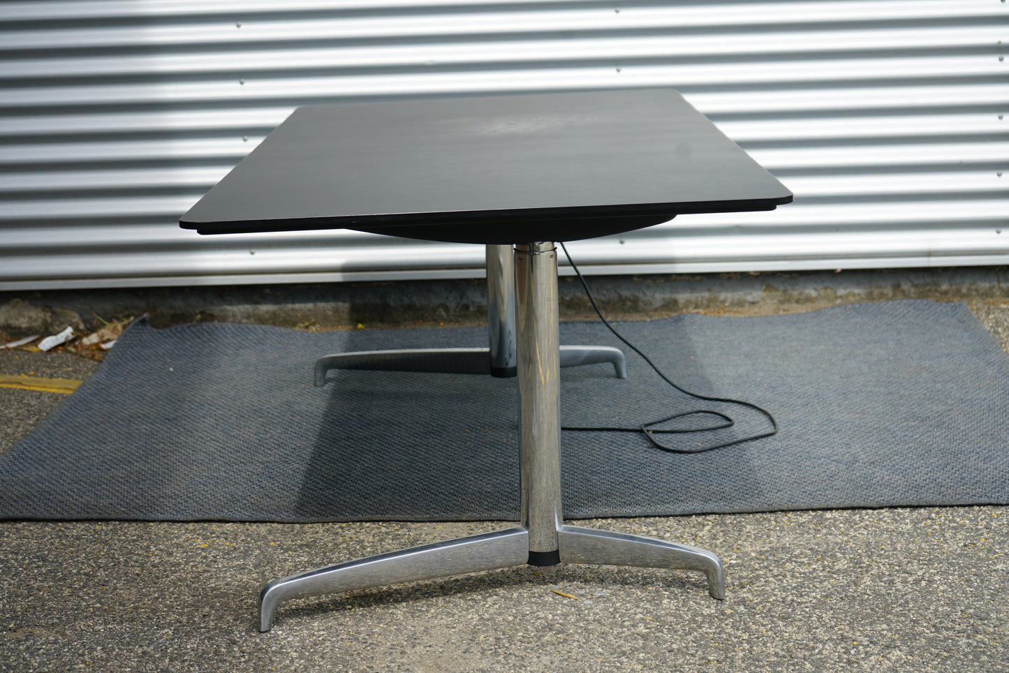 Holmris B8 GENESE hæve-sænkebord 180x90 i sort linoleum set fra siden – moderne skrivebord med elektrisk justering.