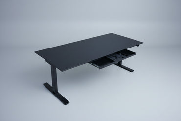 Holmris B8 hæve-sænkebord set skråt med sort linoleumsbordplade og integreret skuffe