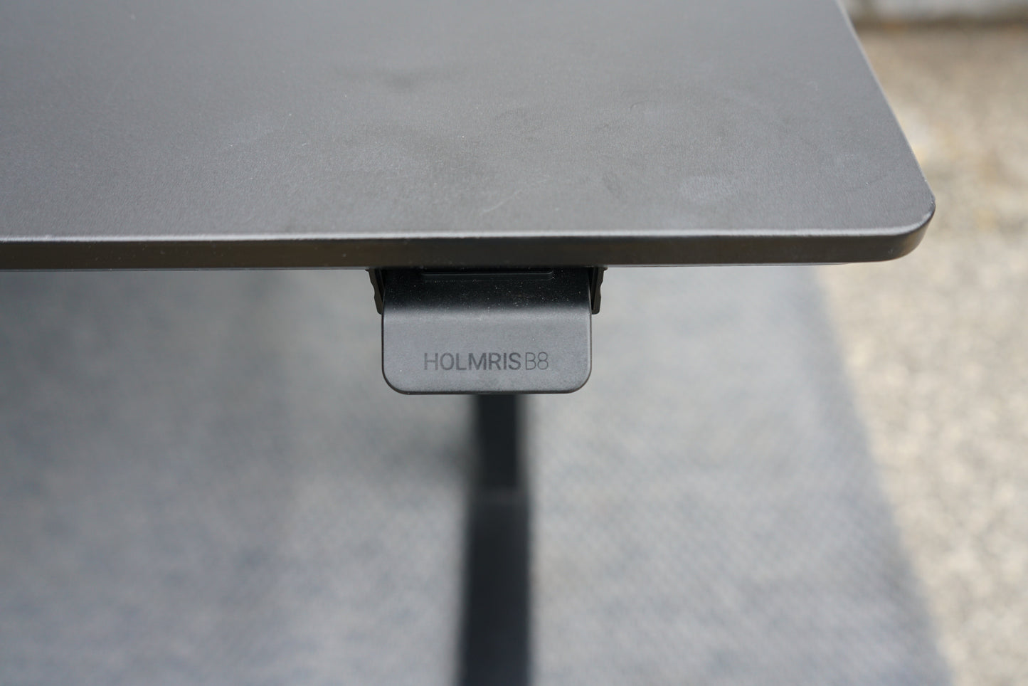 Kontrolknap til højdejustering på Holmris B8 hæve-sænkebord i sort linoleum