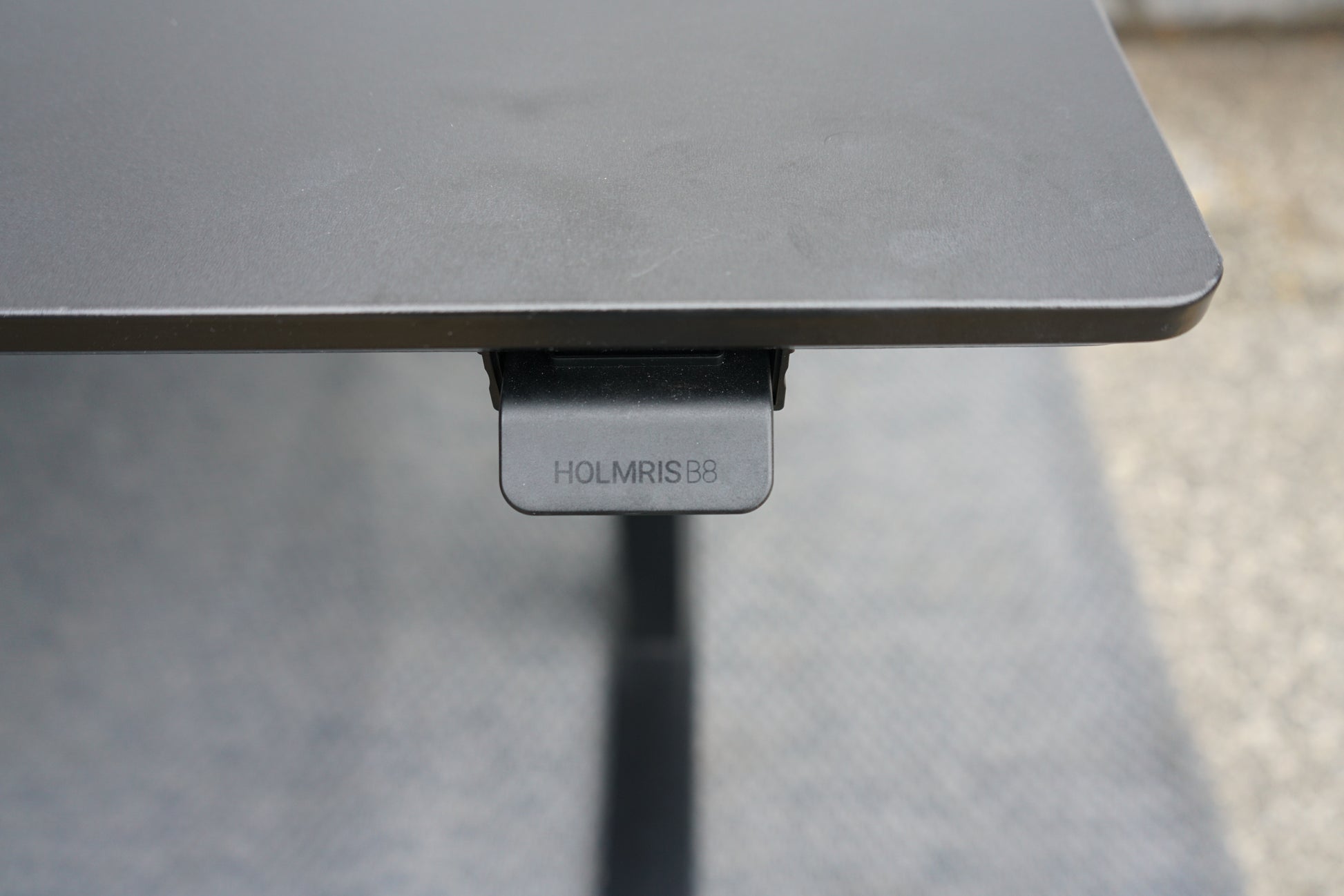 Kontrolknap til højdejustering på Holmris B8 hæve-sænkebord i sort linoleum
