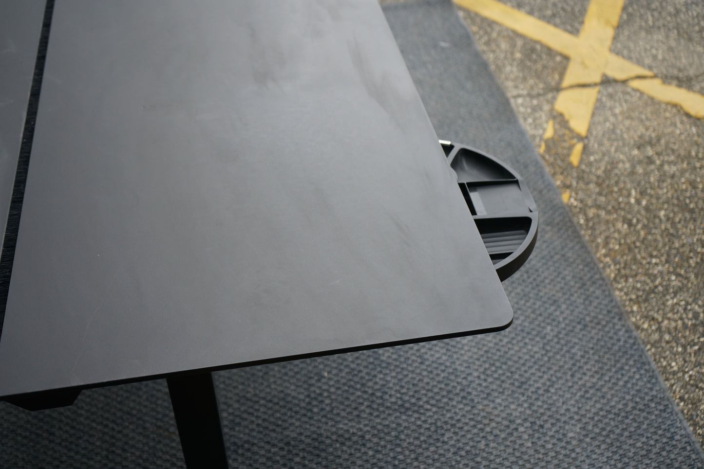 Nærbillede fra siden af Holmris B8 hæve-sænkebord i sort, der viser den indbyggede skuffe og funktionelt design.