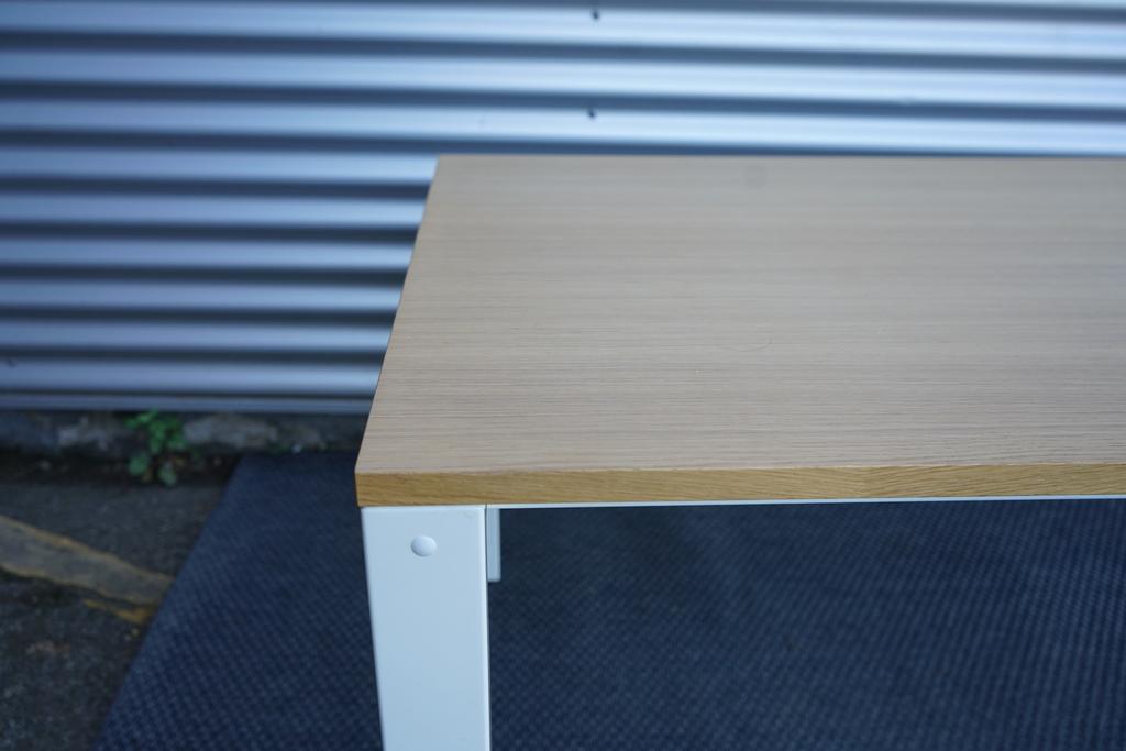 Close-up af Holmris H4 hæve-sænkebord med egetræ bordplade og detaljer på det hvide stel.