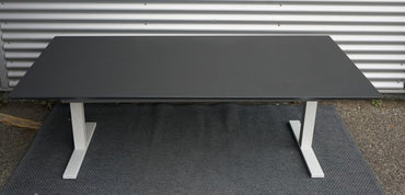 Frontbillede af Holmris hæve-sænkebord 200x100 i sort linoleum med affasede kanter og kabelbakke.