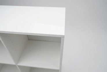 Nærbillede af hvid laminatreol med sokkel og åbne opbevaringsrum til kontor og hjemmekontor.