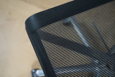 Detalje af sort mesh og poleret stel på ICF kontorstol.