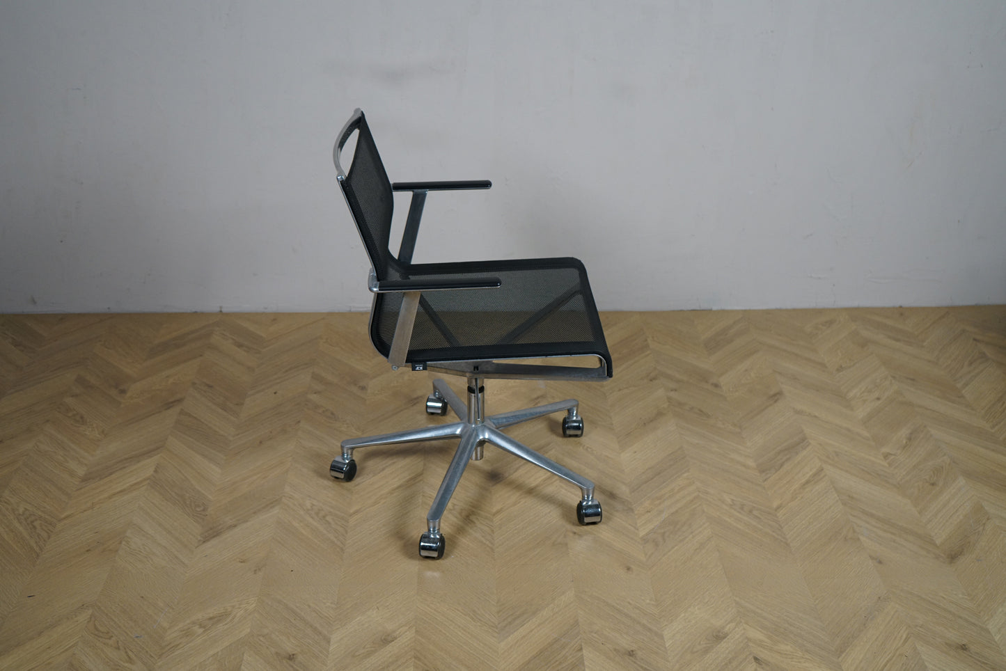 ICF kontorstol set fra siden med armlæn og elegant aluminiumsstel.