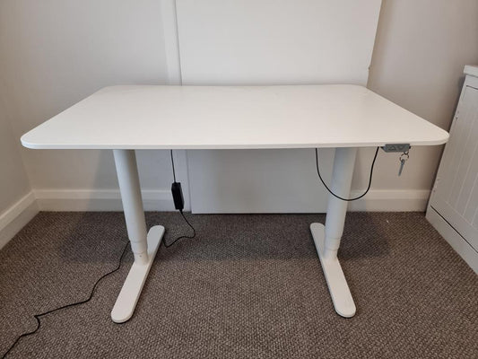 Ikea Bekant hæve-sænkebord i hvid, set forfra. Elegant skrivebord i 120x80 cm med hvid bordplade og hvidt stel i flot stand.