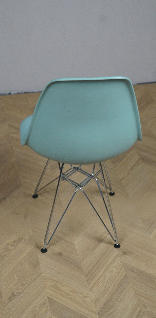 Bagfra visning af IKEA skalstol i turkis med blandet understel og stilrent design.