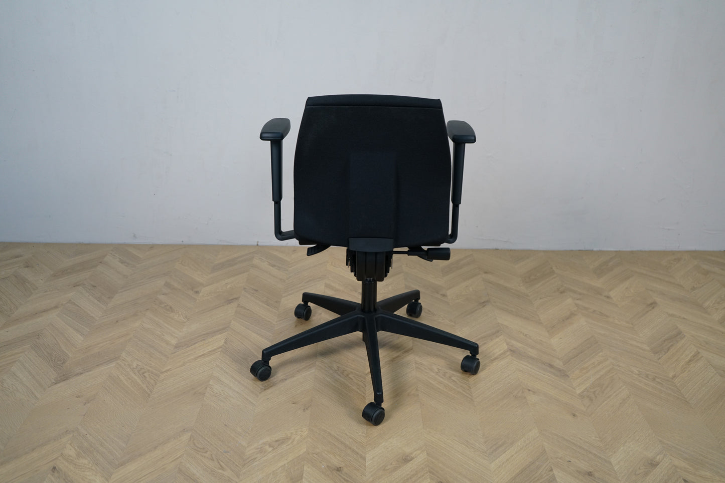 Close-up af sæde og betræk på Interstuhl sort kontorstol med armlæn.