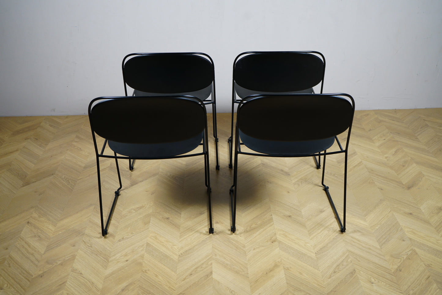 Sæt af 4 sorte Kinnarps stole set bagfra – stilrene og praktiske stole velegnet til kantine, kontor, spisestue eller mødelokale.