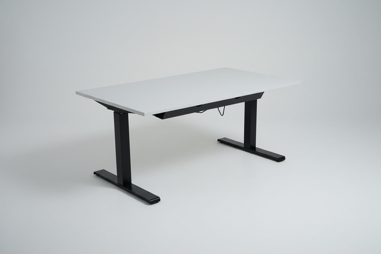 Bagfra af Kinnarps hæve-sænkebord 140x80 cm med sort stel og sort kabelbakke til organiseret kabelstyring.