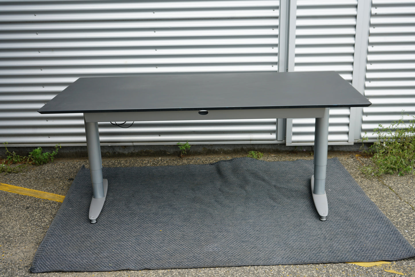 Kinnarps hæve-sænkebord 200x100 cm i sort linoleum – set bagfra med kabelbakke
