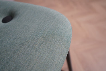 Detaljebillede af Kinnarps barstol – polstret sæde i stof og elegant sort metalstel