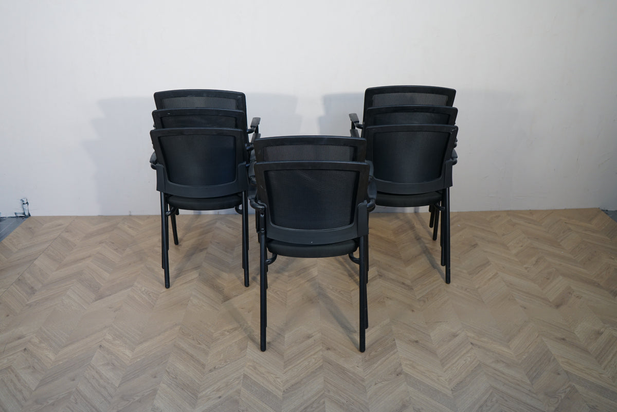 Sort stabelbare møde- og konferencestole med mesh-ryg set samlet bagfra.