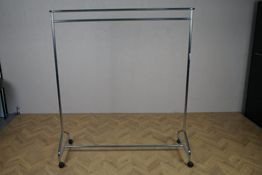 Krom tøjstativ med hattehylde på hjul – praktisk og flytbart stativ set fra skrå vinkel