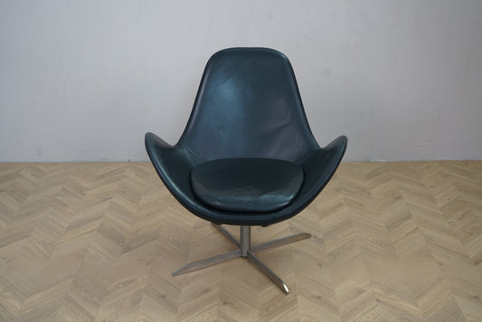 Lænestol i sort læder med løs sædehynde og drejefod set forfra