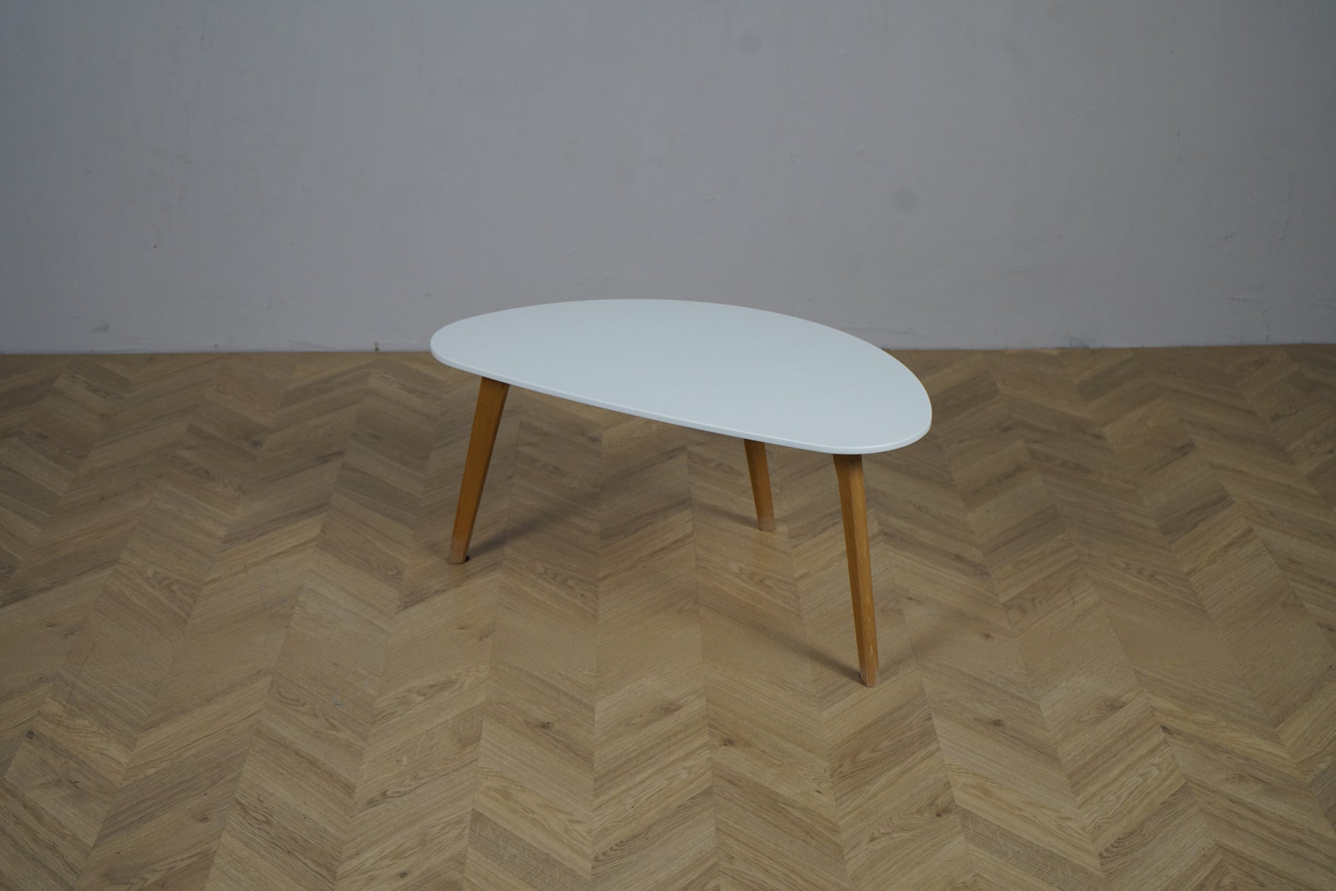 Lille hvidt kaffebord 84x48 cm med træben set forfra i moderne design