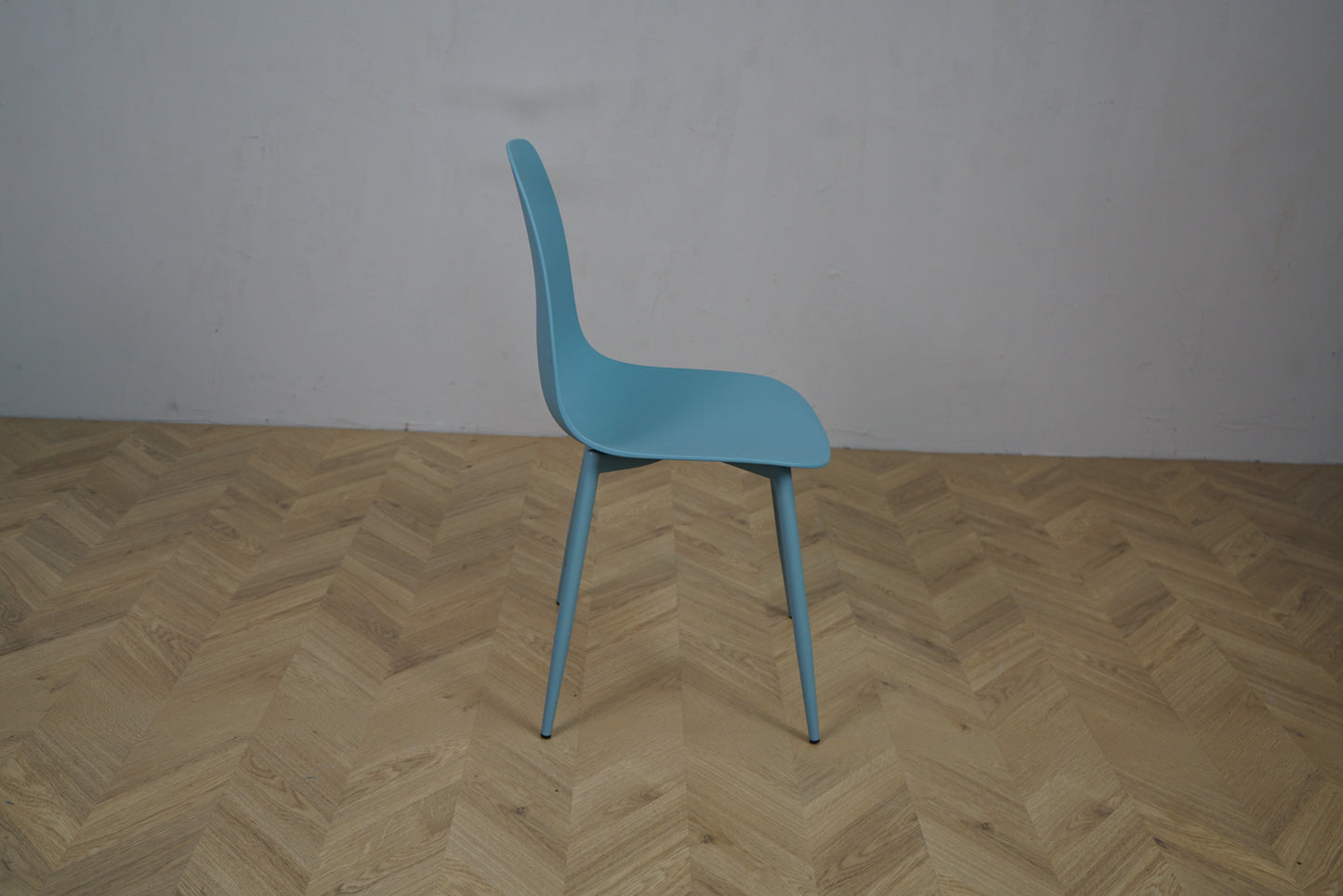 Lite kantinestol i pastelblå farve set fra siden – funktionel og let stol i nordisk design til spise- og møderum.