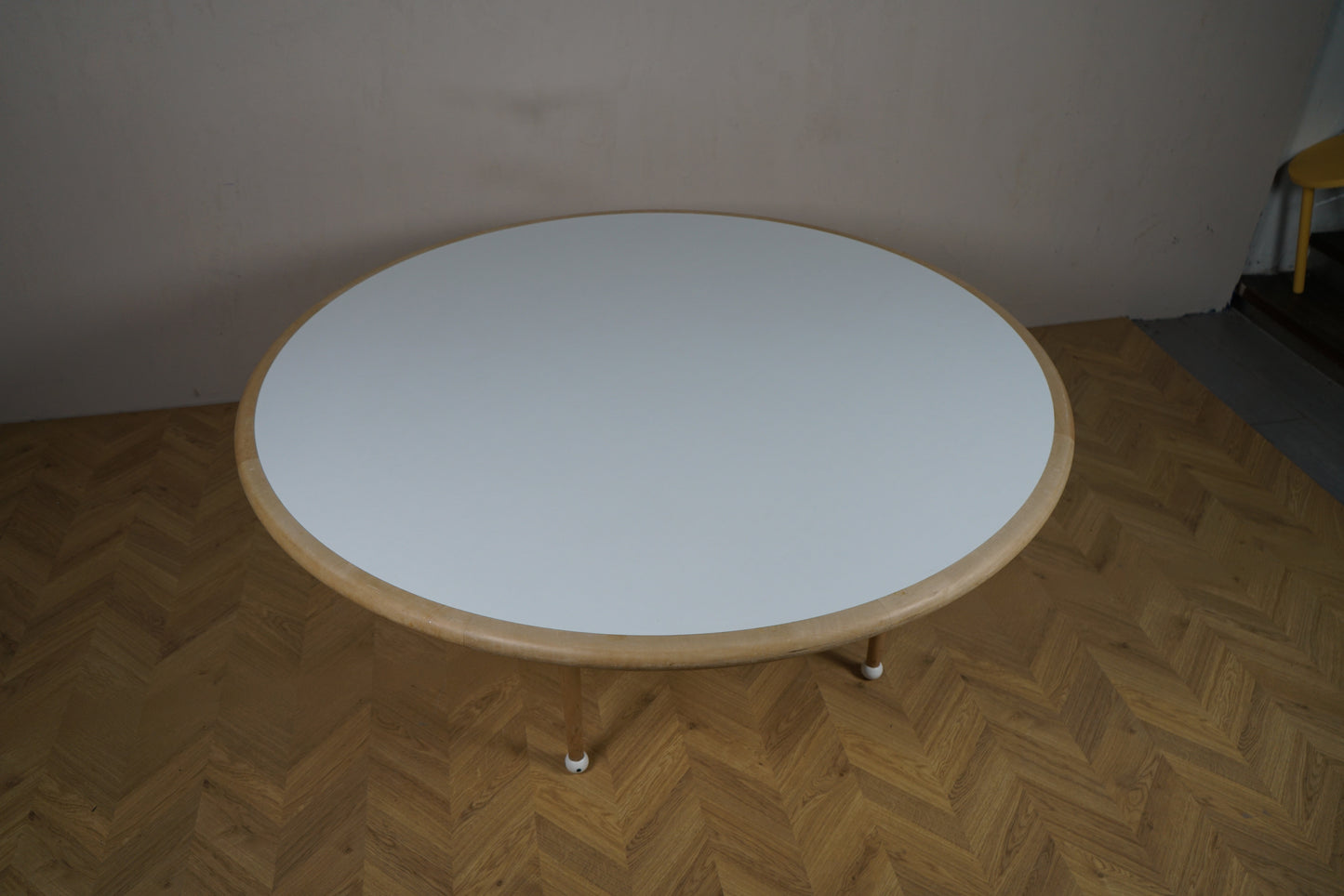 Lite rundt bord Ø160 cm set ovenfra – hvid bordplade med elegant trækant.