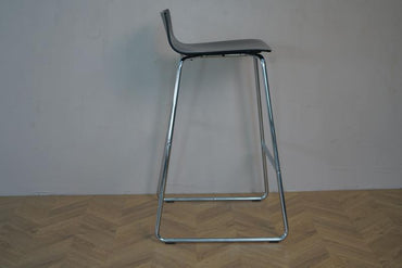 Sideprofil af sort Magnus Olesen barstol – viser slank silhuet og fodstøtte.