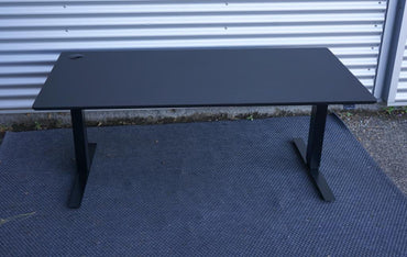 Frontvisning af Martela hæve-sænkebord i sort linoleum 160x80 cm med to motorer og lydløs højdejustering.