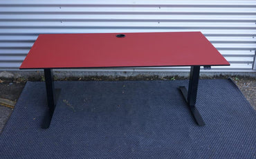 Martela hæve-sænkebord i rød linoleum 160x80 cm set fra front – stilrent kontorbord med højdejustering og kabelgennemføring.