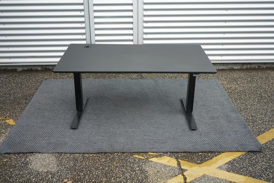 Martela hæve-sænkebord i sort med integreret stikkontakt – set forfra.