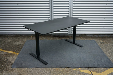 Martela hæve-sænkebord i sort linoleum 130x80 cm set fra skrå vinkel