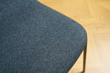 Nærbillede af polstret mørkeblå uldstof på Materia stabelbare stole – slidstærkt, komfortabelt og elegant design.