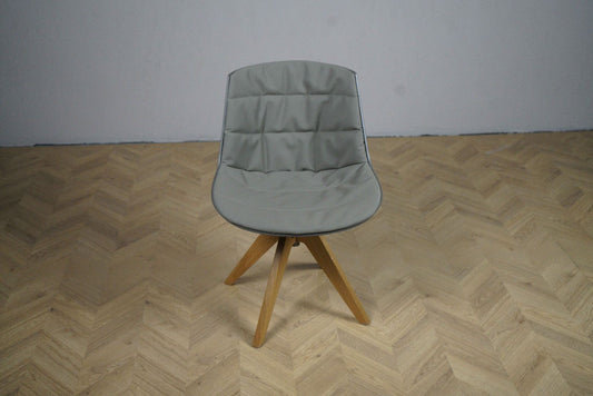 MDF Italia Flow Chair med grå frontpolstring og drejeligt brunligt egetræsstel – set forfra.