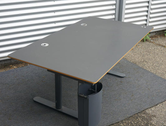 Montana HiLow hæve-sænkebord 160x90 cm i sort linoleum med affasede kanter, set fra skrå vinkel.