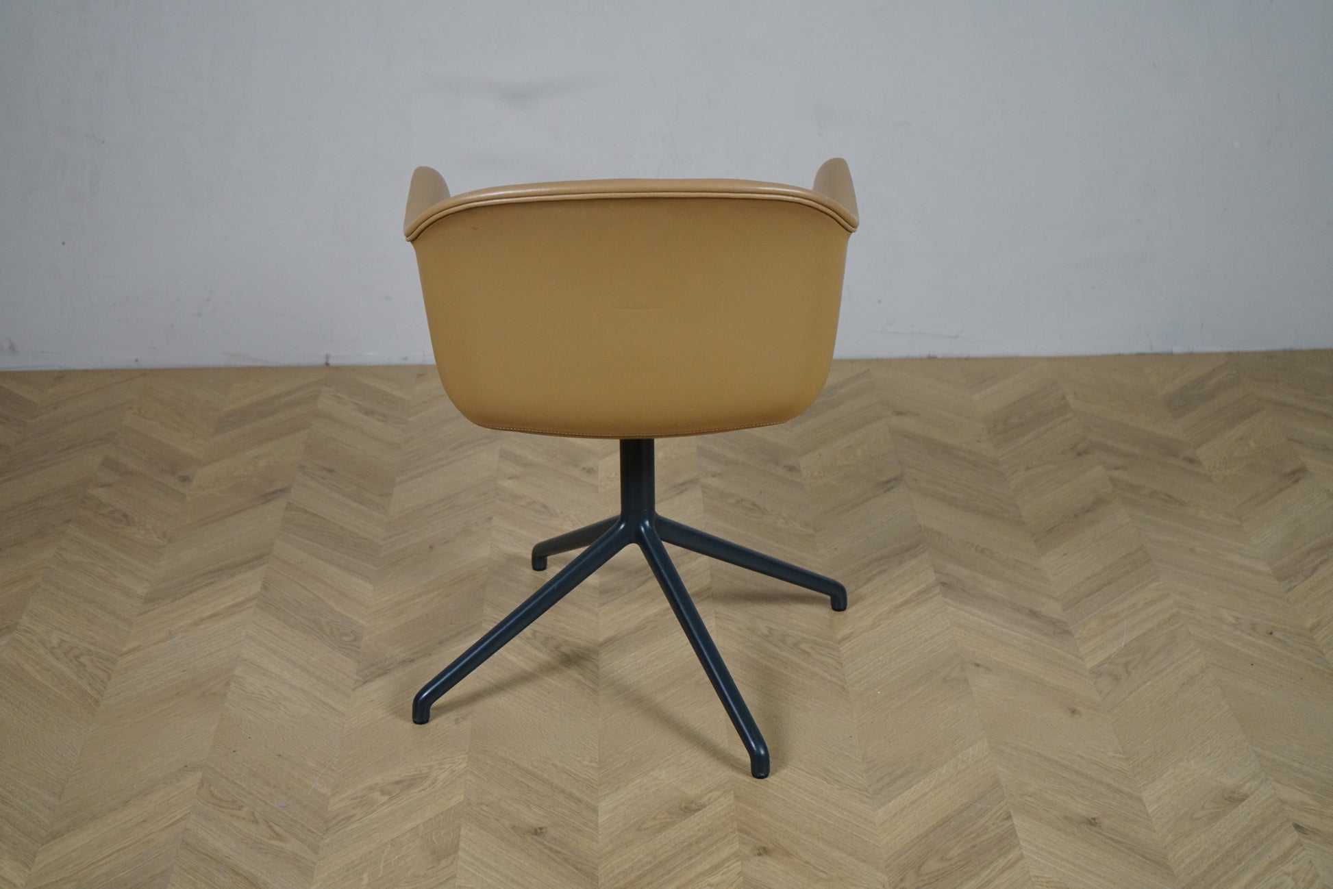 Muuto Fiber Armchair set bagfra – stilrent design med sort metalbase og blød læderskal.