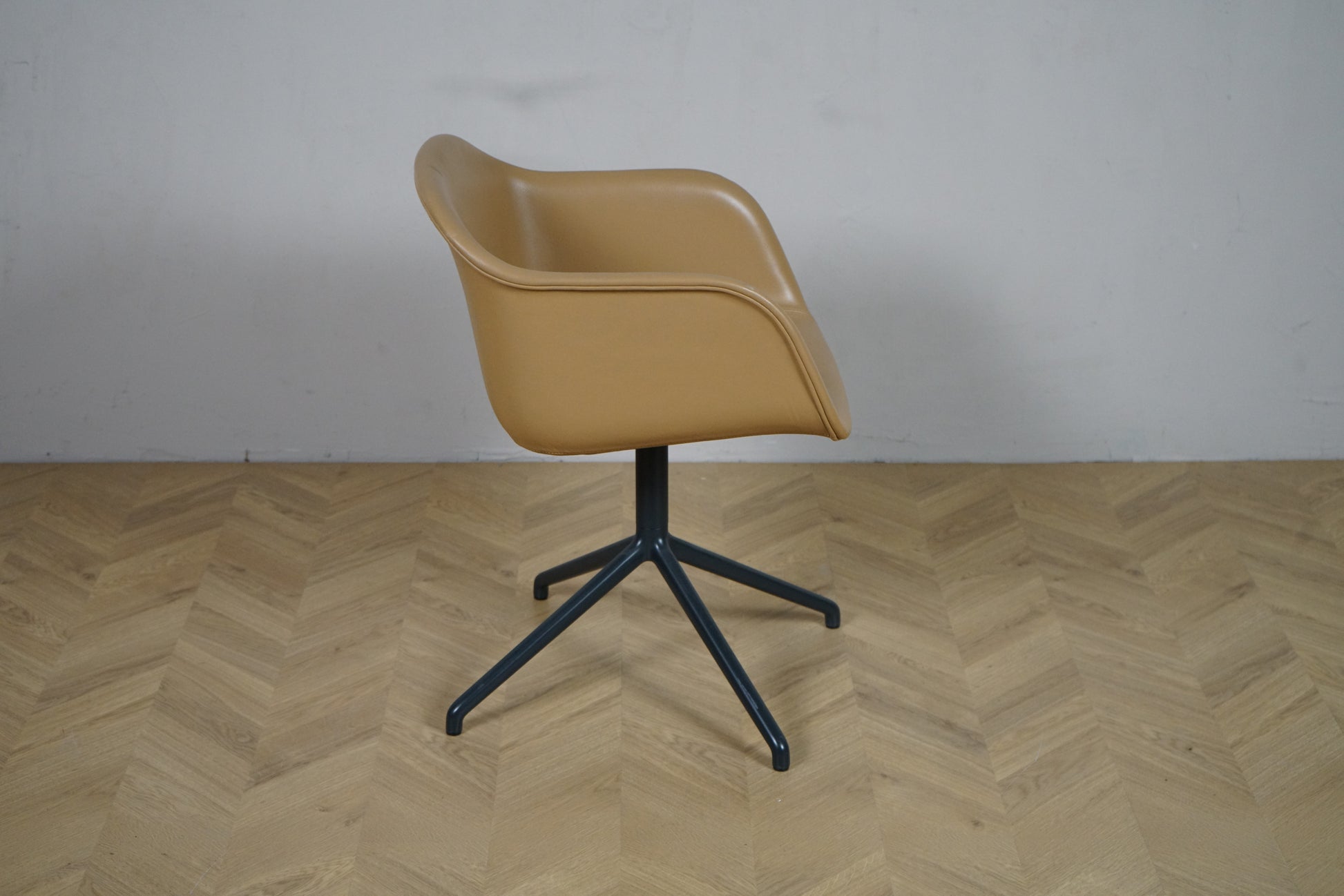 Muuto Fiber Armchair i cognac læder set fra siden – ergonomisk form og minimalistisk udtryk.