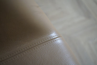 Muuto Fiber Armchair i cognac læder set fra skrå vinkel – elegant dansk design med firebenet sort stel.